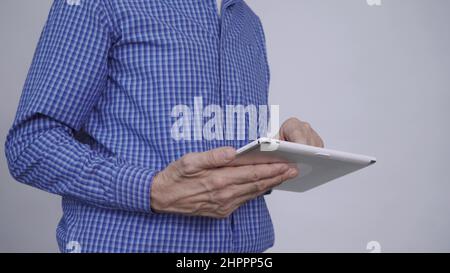 Ein Mann, der einen Tablet-Computer in der Hand hält Stockfoto