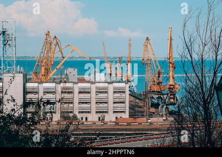Bulk-Carrier-Schiff unter Ladung von Klinker Ladung Verladung durch Landkrane mit Greifern. Seehandel Hafentätigkeit. Bulk-Cargo-Terminal des Seehafens Stockfoto