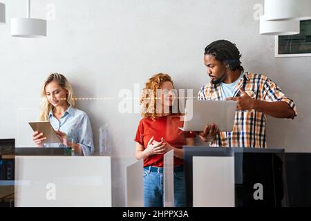 Glückliche, erfolgreiche junge Geschäftskollegen, die im Büro arbeiten. Technologiekonzept für Geschäftsleute Stockfoto