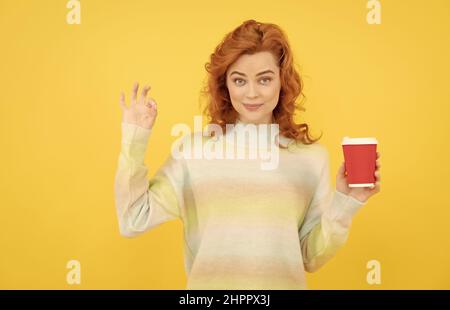 Ausgezeichneter Geschmack. Glücklich Rotschopf Frau trinken Kaffee. Take Away Getränk. Mädchen trinken Tee. Stockfoto