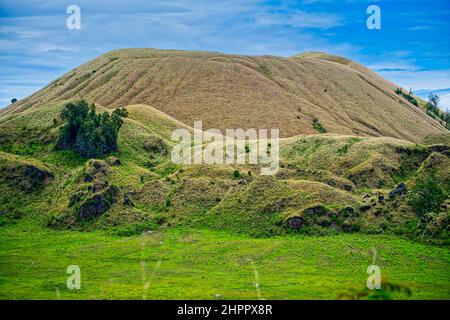 Wurung Crater ist ein hügeliges Gebiet, das über eine grüne Graslandschaft (Savanne) mit einem Überzug in Form eines Bergkraters verfügt. Die Hügel sind umgeben Stockfoto