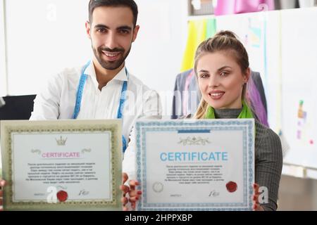 Mann und Frau Team halten Zertifikat, Bestätigung der hohen Qualität und Service Stockfoto