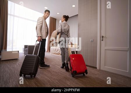 Liebevolles Paar mit Gepäck im Hotelzimmer Stockfoto