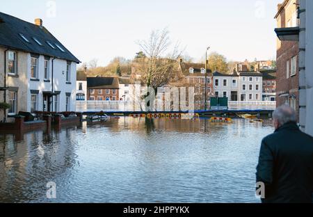 Ein Anwohner blickt auf den Fluss Severn in Bewdley, in Worcestershire, wo das Hochwasser die Hochwasserabwehr der Stadt aufgrund der starken Regenfälle des Sturms Franklin verletzt hat. Bilddatum: Mittwoch, 23. Februar 2022. Stockfoto