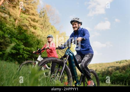 Low-Angle-Ansicht von glücklichen aktiven älteren Frauen Freunde Radfahren zusammen im Freien in der Natur. Stockfoto