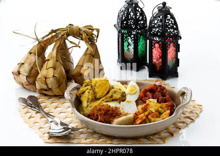 Ketupat Lebaran. Traditionelles festliches Gericht aus Reiskuchen mit mehreren Beilagen, beliebt während der Eid al Fitr Feierlichkeiten. Serviert mit Samba Stockfoto