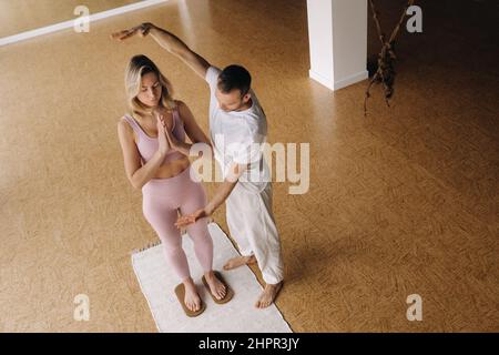 Ein Mann und eine Frau machen Yoga auf Brettern mit Nägeln im Fitnessstudio. Stockfoto