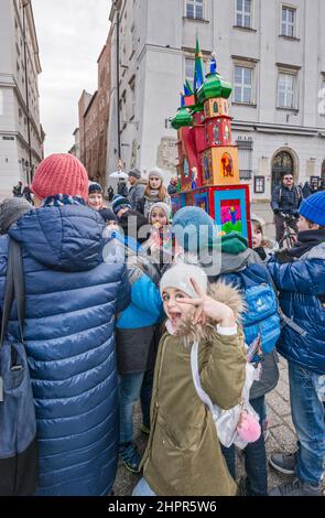 Schulkinder, die die Krippe von Kraków Szopka tragen, die von ihnen in der Schule gemacht wurde, für die Ausstellung während des jährlichen Wettbewerbs im Dezember, Veranstaltung, die in die Liste des UNESCO-Weltkulturerbes aufgenommen wurde, auf dem Hauptmarkt in Kraków, Polen Stockfoto