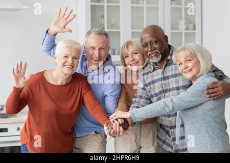 Mehrere Rassen Gruppe von älteren Menschen Freunde halten Hände und winken Stockfoto