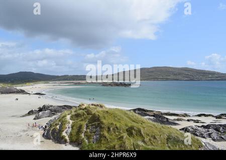 Wunderschöner Sandstrand an der irischen Küste. Sommerurlaub. Felsen und Wiesen. Hügel. Blauer Himmel mit einigen Wolken. Irland. Stockfoto