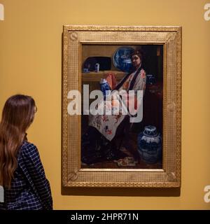 London, Großbritannien. 23. Februar 2022. Eine Frau betrachtet „Purple and Rose: The lange Leizen of the Six Marks“, 1864, von James McNeill Whistler. Vorschau auf „Whistlers Frau in Weiß: Joanna Hiffernan“, die erste Ausstellung, die sich mit der wichtigen Rolle von James McNeill Whistlers irischem Model Joanna Hiffernan befasse. Vom 26. Februar bis zum 22. Mai 2022 sind über 70 Werke an der Royal Academy of Arts zu sehen. Kredit: Stephen Chung / Alamy Live Nachrichten Stockfoto