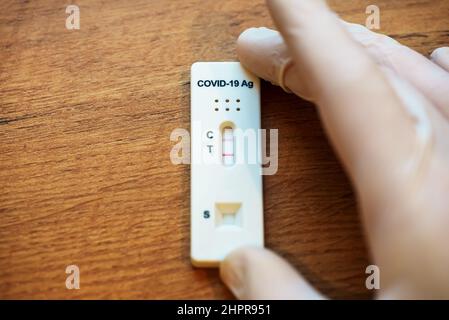 Virologe zeigt positiven Antigen-Schnelltest auf Coronavirus. Stockfoto