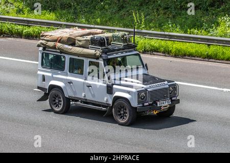 Weißer Land Rover Defender 2014 mit 2198cc 6-Gang-Schaltgetriebe, Campingausrüstung für Expeditionen über Land, Benzinkanister als Ersatz, Winde und Zelte aus Segeltuch. Stockfoto