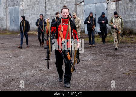 SIURTE, UKRAINE - 19. FEBRUAR 2022 - Ein Mann trägt Gewehre während einer militärischen Übung für Zivilisten, die von der Bewegung der Veteranen von Zakarpattia, Stockfoto