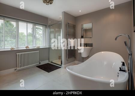 Swavesey, Cambridgeshire - August 22 2018: Modernes Luxusbad der Spitzklasse mit traditioneller Badewanne, Duschkabine, gefliestem Boden, Handtuchhalter und Handtuchhalter Stockfoto