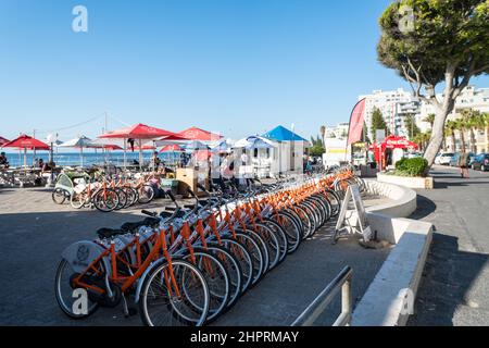 Fahrradverleih, Fahrradverleih, Reihe von Fahrrädern an einer Straße am Strand in Sea Point, Kapstadt, Südafrika Konzept Freizeit-oder Freizeitaktivitäten aufgereiht Stockfoto