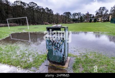 Spiegelung der Torpfosten im Flutwasser sagt für eine Weile kein Fußball, alter Abfalleimer beschädigt und vernachlässigt, Stockfoto