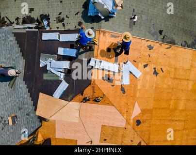 Bauroofer Installation von Dachziegeln auf der Hausbaustelle bei der Arbeit Installation von Dachschindeln Stockfoto