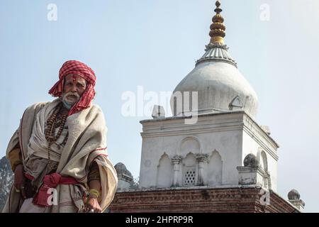 Kathmandu, Nepal. 23rd. Februar 2022. Ein Sadhu, Anhänger von Lord Shiva, steht vor einem Tempel in einem heiligen Pashupatinath Tempel vor dem bevorstehenden Maha Shivaratri Festival in Kathmandu, Nepal am 23. Februar 2022. Maha shivaratri, ein Festival, das Lord Shiva gewidmet ist. Sadhus aus Nachbarländern sind vor dem bevorstehenden Maha Shivaratri Festival angekommen. (Foto: Abhishek Maharjan/Sipa USA) Quelle: SIPA USA/Alamy Live News Stockfoto