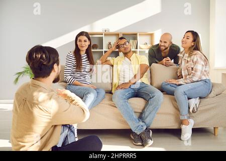 Glückliche junge Freunde unterhalten sich und genießen Zeit zusammen während des Treffens zu Hause am Wochenende. Stockfoto