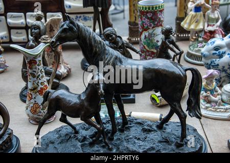 Flohmarkt in Paris, Frankreich. Bronze Pferd und Fohlen und andere Figuren. Retro Shopping Hobby Hintergrund Stockfoto