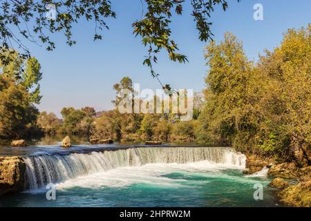 Türkisfarbenes Wasser des Manavgat-Flusses, das über den Manavgat-Wasserfall fließt. Stockfoto