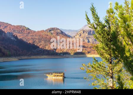 Kleines Ausflugsboot auf dem Oymapinar-Staudamm im Taurusgebirge. Stockfoto