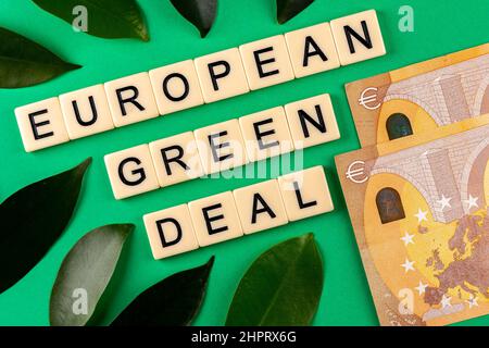 Satz „European Green Deal“, bestehend aus Buchstaben auf grünem Hintergrund mit grünen Laves und 50-Euro-Banknoten. Foto aufgenommen unter künstlichem, Stockfoto