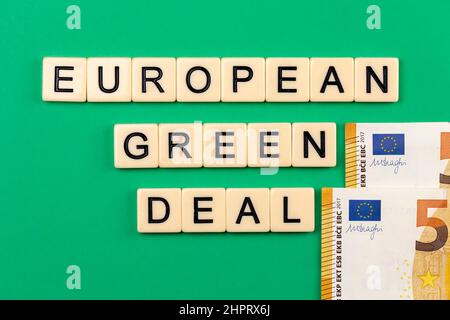 Satz „European Green Deal“, bestehend aus Buchstaben auf grünem Hintergrund mit 50-Euro-Banknoten. Foto aufgenommen unter künstlichem, weichem Licht Stockfoto