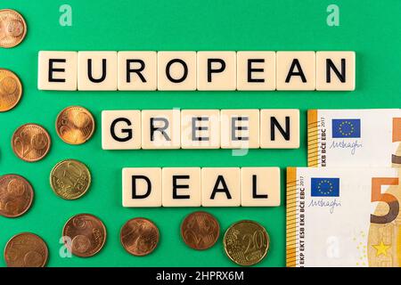 Satz „European Green Deal“, bestehend aus Buchstaben auf grünem Hintergrund mit Eurocent und 50-Euro-Banknoten. Foto unter künstlichem, s Stockfoto