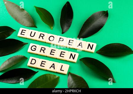 Satz „European Green Deal“, bestehend aus Buchstaben, die auf den grünen Hintergrund mit grünen Laven gesetzt wurden. Foto aufgenommen unter künstlichem, weichem Licht Stockfoto