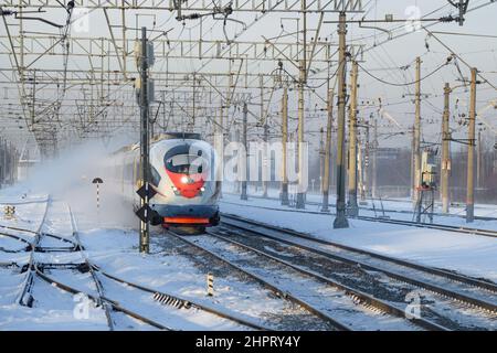 SANKT PETERSBURG, RUSSLAND - 21. DEZEMBER 2021: Hochgeschwindigkeitszug EVS1-15 'Sapsan' an einem Dezembernachmittag in Bewegung. Umgebung von St. Petersburg Stockfoto