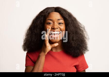 Hey, Du. Fröhliche Schwarze Dame, Die Die Hand Nahe Am Mund Hält Und Eine Ankündigung Macht Stockfoto