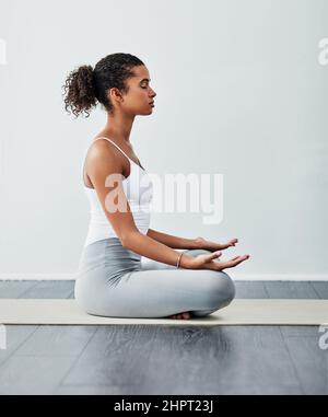 Yoga hilft mir bei so viel im Leben. Aufnahme einer sportlichen jungen Frau, die Yoga praktiziert. Stockfoto