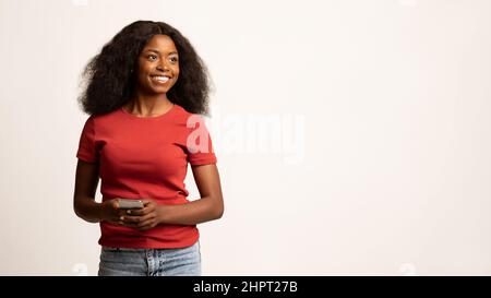Portrait Of Beautiful Young Black Female Mit Smartphone In Den Händen Stockfoto