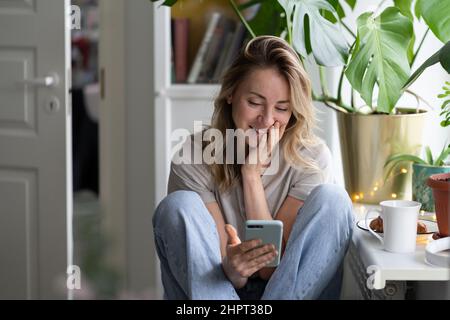 Glückliche Frau mit Smartphone im Video-Chat-Chat sprechen In sozialen Netzwerken sehen lustige Videos Stockfoto