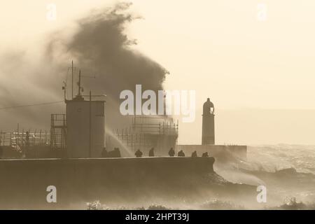 Porthcawl, South Wales, Großbritannien. 18. Februar 2022. Britisches Wetter: Große Wellen stürzen heute Morgen über die Verteidigung des Meeres, als der Sturm Eunice eintrifft. Stockfoto