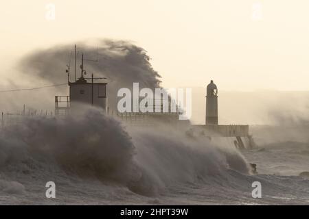 Porthcawl, South Wales, Großbritannien. 18. Februar 2022. Britisches Wetter: Große Wellen stürzen heute Morgen über die Verteidigung des Meeres, als der Sturm Eunice eintrifft. Stockfoto