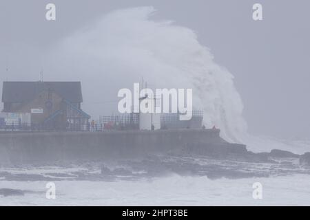 Porthcawl, South Wales, Großbritannien. 18. Februar 2022. Britisches Wetter: Große Wellen stürzen heute Morgen über die Verteidigung des Meeres, als der Sturm Eunice eintrifft. Stockfoto