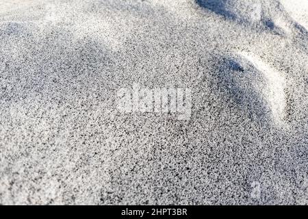 Schwarzer Ruß aus dem Kesselraum auf weißem Schnee. Natürlicher Hintergrund. Schnee gemischt mit Kohleroß, schlechte Ökologie. Umweltverschmutzung Stockfoto