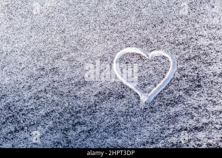 Schwarzer Ruß aus dem Kesselraum auf weißem Schnee. Natürlicher Hintergrund. Schnee gemischt mit Kohleroß, schlechte Ökologie. Umweltverschmutzung. Ein Herz ist schmerzhaft Stockfoto