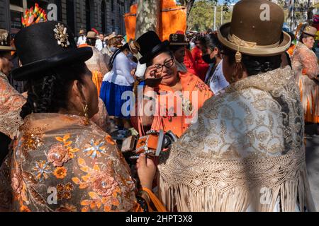 Bolivianische Frauen tragen traditionelle bestickte bunte Kleider und Hüte während der Dia de la Hispanidad in der Gracia Avenue in Barcelona, Spanien. Stockfoto