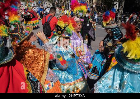 Bolivianische Frauen tragen traditionelle bestickte Kleider und farbenfrohe Hüte während einer Pause bei der Parade zum Hispanic Heritage Day in Barcelona, Spanien Stockfoto