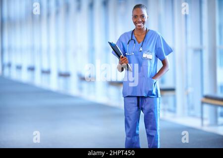 Lächeln nach der Operation. Porträt einer jungen Ärztin mit Patientenakte. Stockfoto