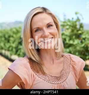 Zu Hause im Weinberg. Porträt einer reifen Frau, die einen Tag in den Weinbergen genießt. Stockfoto