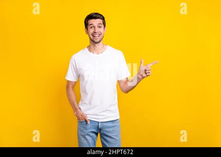 Foto von lustigen Millennial Brunet guy Index Förderung tragen Casual Tuch isoliert auf gelbem Hintergrund Stockfoto