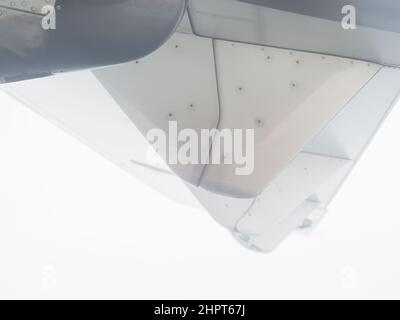 Ein Fragment des Flügels eines kleinen Flugzeugs ist vom Fenster aus vor dem Hintergrund des nebligen Himmels zu sehen Stockfoto