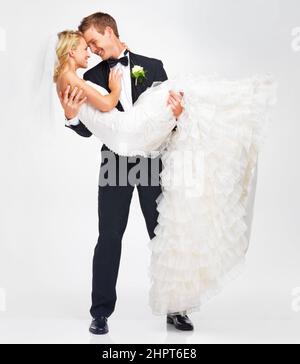 Ich will immer hier sein, um sie zu unterstützen. Attraktive junge Bräutigam hält seine Braut, wie sie sich bereit zu küssen. Stockfoto