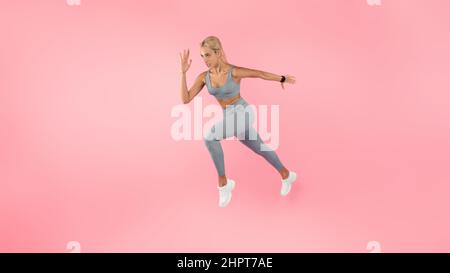 Seriöse Frau läuft auf rosa Studio Hintergrund Stockfoto