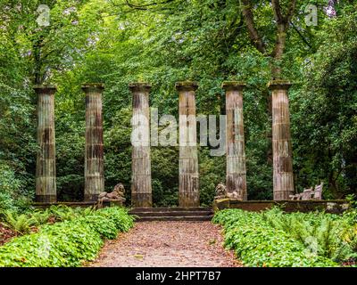 Dorische Säulen und steinerne Löwen mit Wald hinter den Harlow Carr Gardens in Harrogate, North Yorkshire. VEREINIGTES KÖNIGREICH Stockfoto